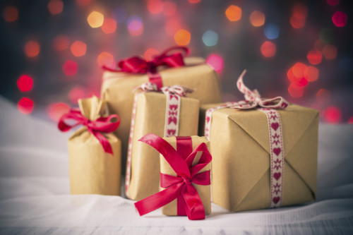 Packets of presents under the Christmas tree on the background of colored lights