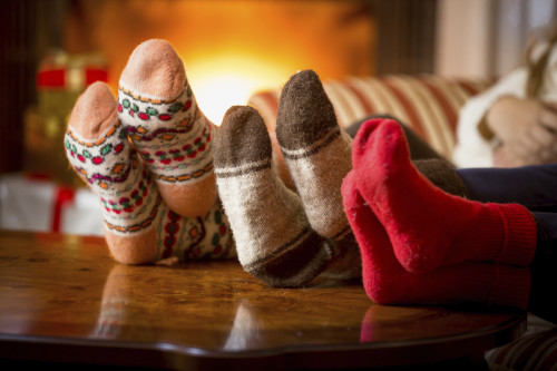 Closeup photo of family feet in wool socks at fireplace