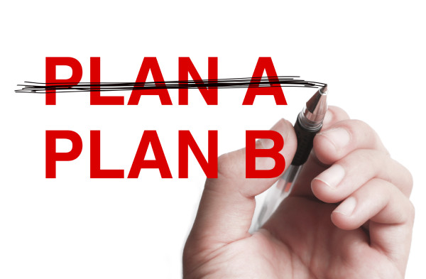 Hand with pen is writing " Business Plan" on transparent white board.